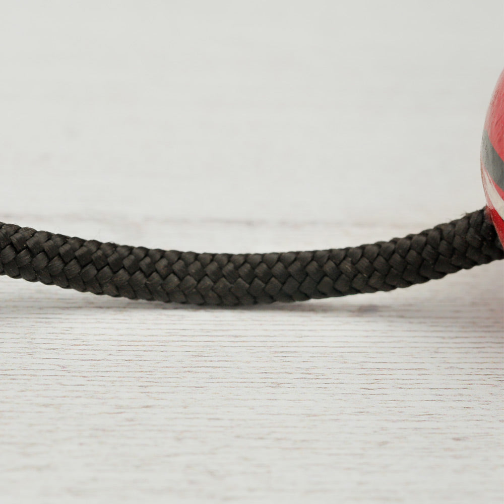 Close-up of the rope connecting the Kashaka shaker balls, showing its texture and attachment details.