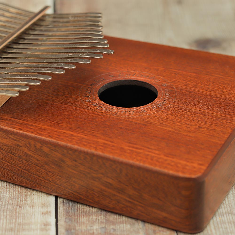 Close-up of the main sound hole on the Yulin Wooden Kalimba showing its position and size.