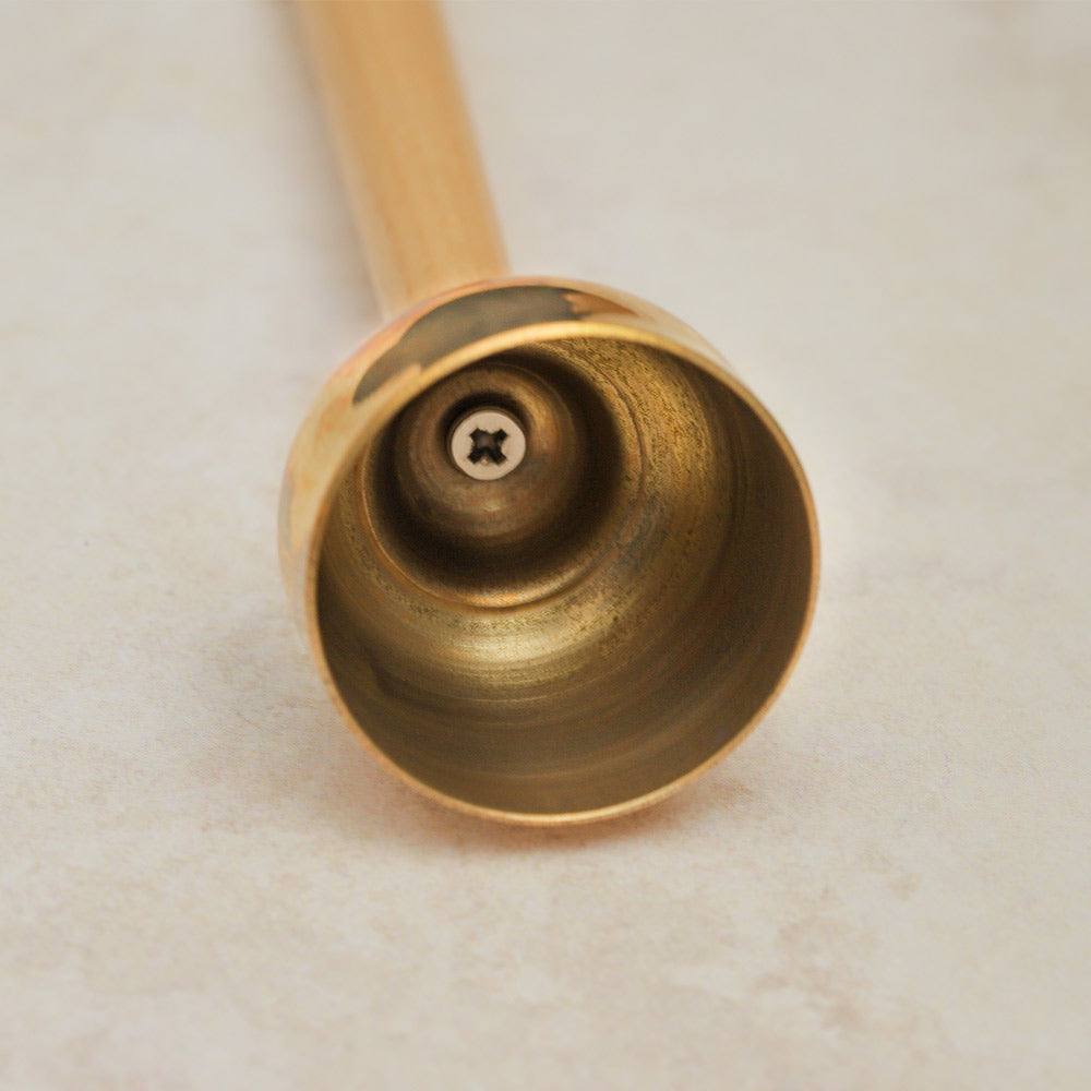  Close-up of the interior of a large Matsu brass bell, showing the smooth, reflective surface of the metal.