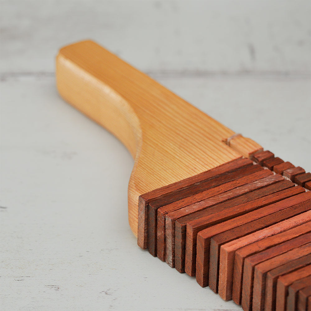 Close-up of the Matsu Kokoriko showing the pine wood handle and rectangular percussive blocks.