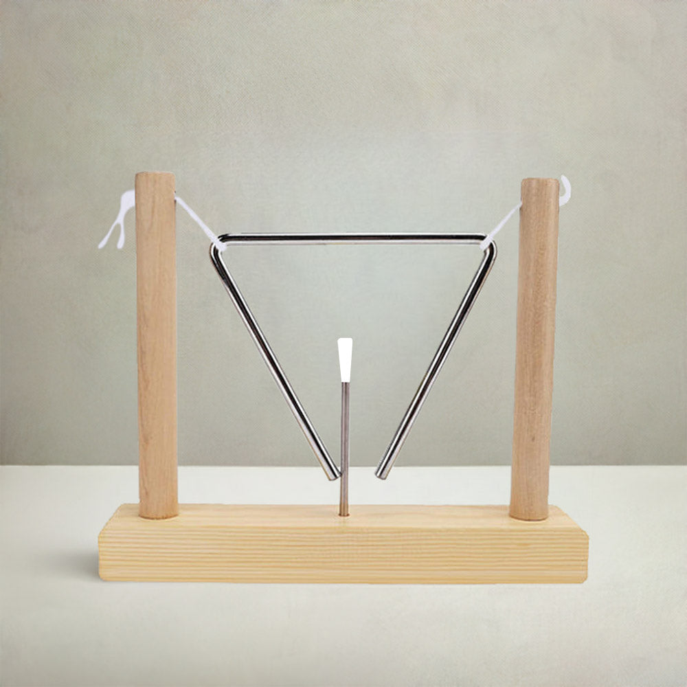 Matsu Triangle instrument made of metal with a pine wood frame, displayed on a light wooden surface with grey stone textured background. 