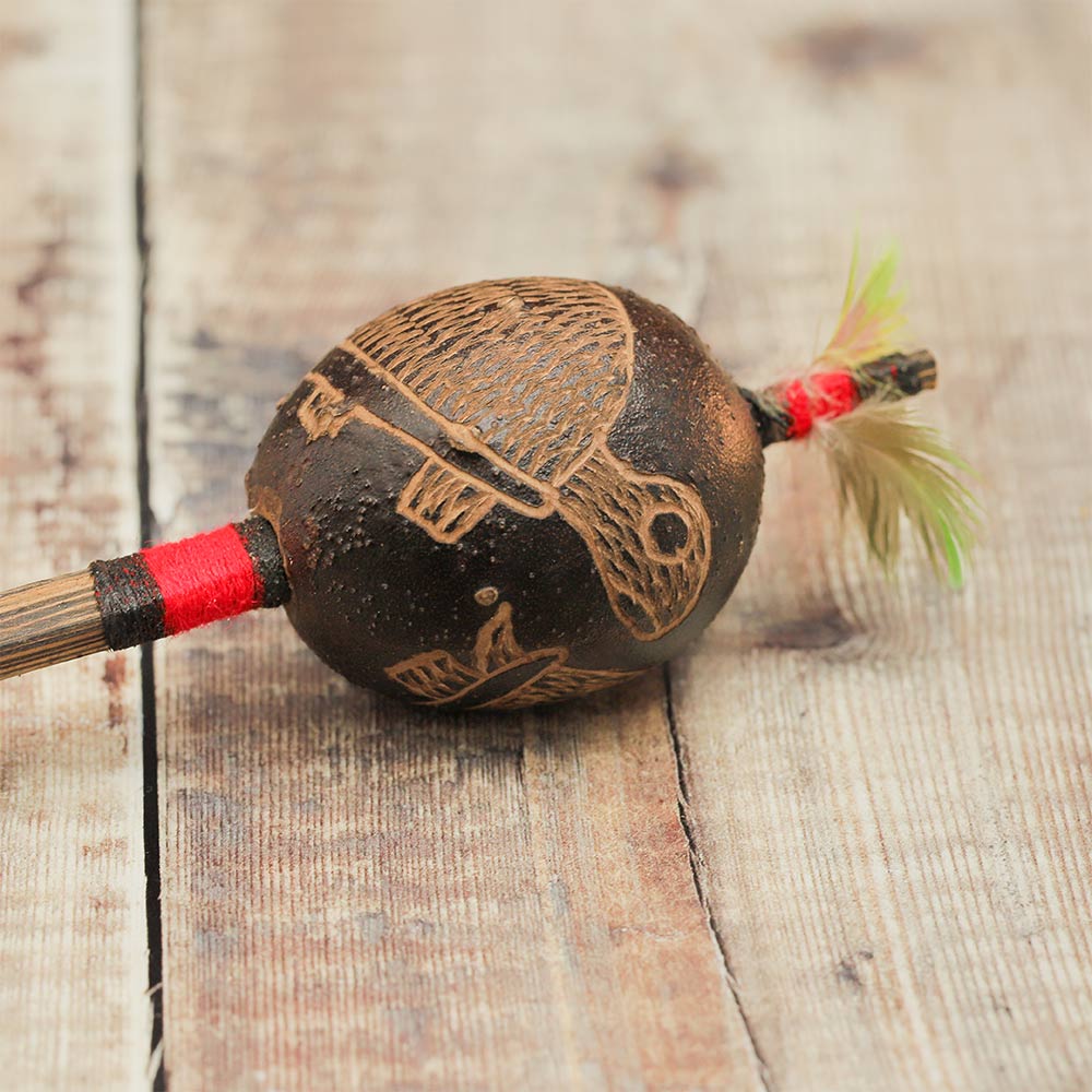 Close-up of the Peruvian Shipibo shaker head, highlighting the detailed carved turtle design on the chonta wood handle.