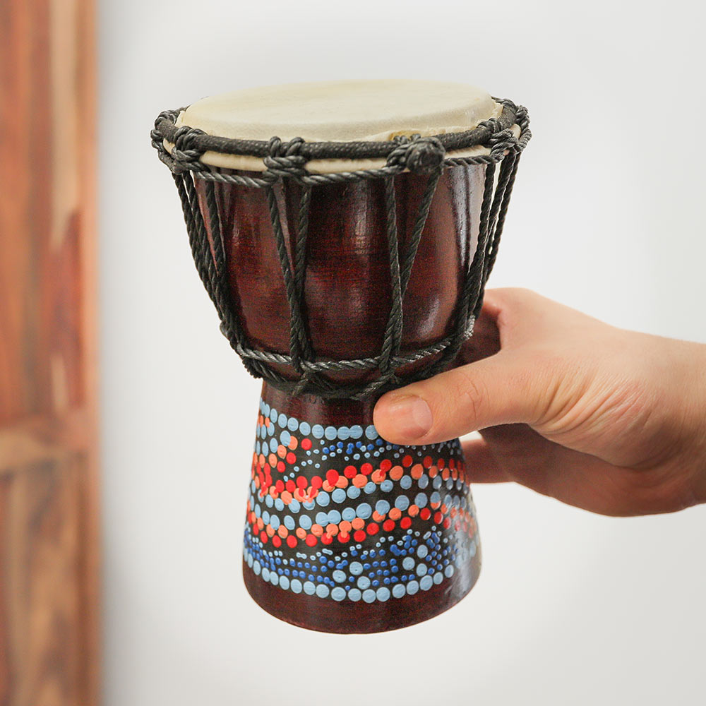 Handmade 8-inch Pura Djembe Drum from Bali, featuring a natural goat hide top and unique dot-painted design. Ideal for beginners and children.
