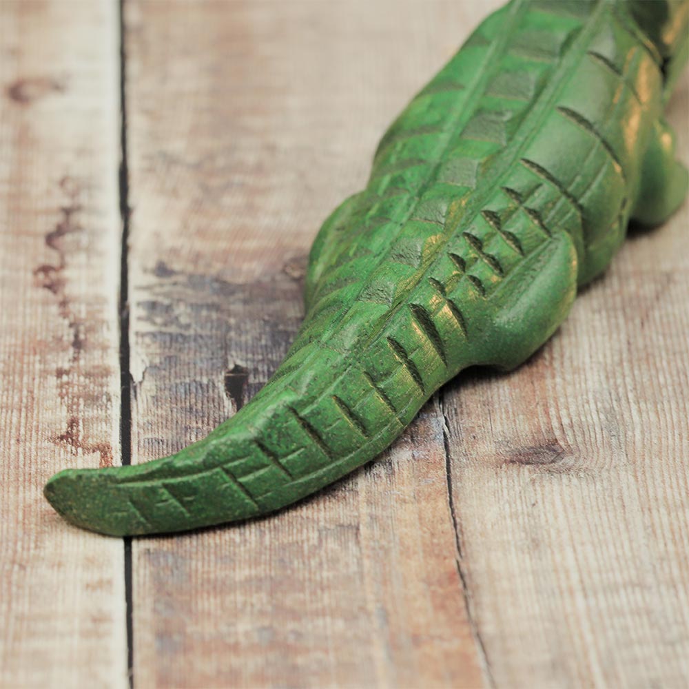 Close-up of the wooden crocodile guiro's ridged tail and back, highlighting the playing surface.