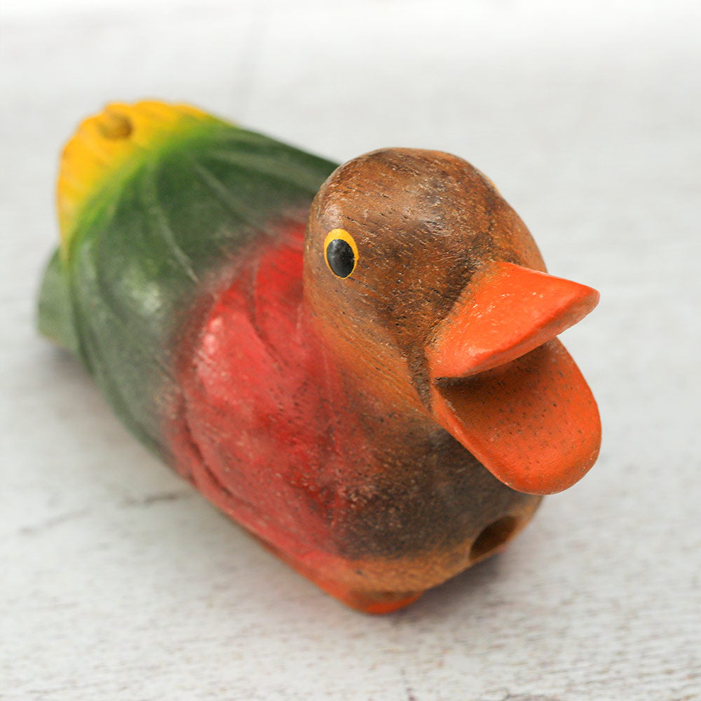 Close-up of the face of a wooden sitting duck whistle, highlighting the details of the carving.