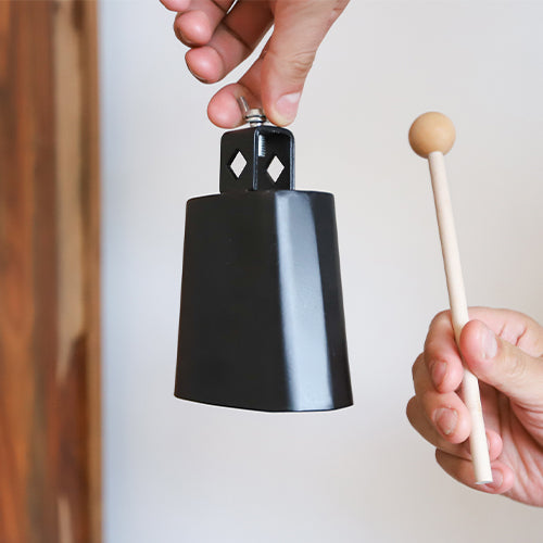 hand holding cow bell with beater